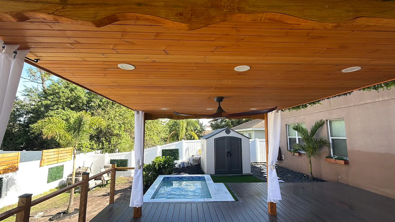 Covered patio pavilion with a warm tongue-and-groove wood ceiling over a deck and spa