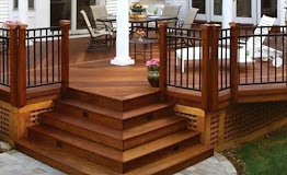 Custom hardwood deck with cascading stairs and a black metal railing