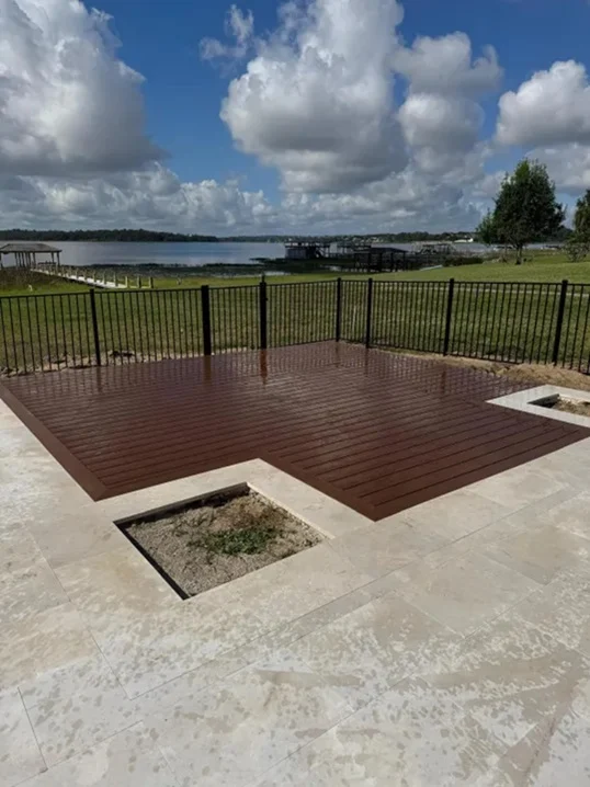 Composite deck with a travertine surround overlooking a Central Florida lake
