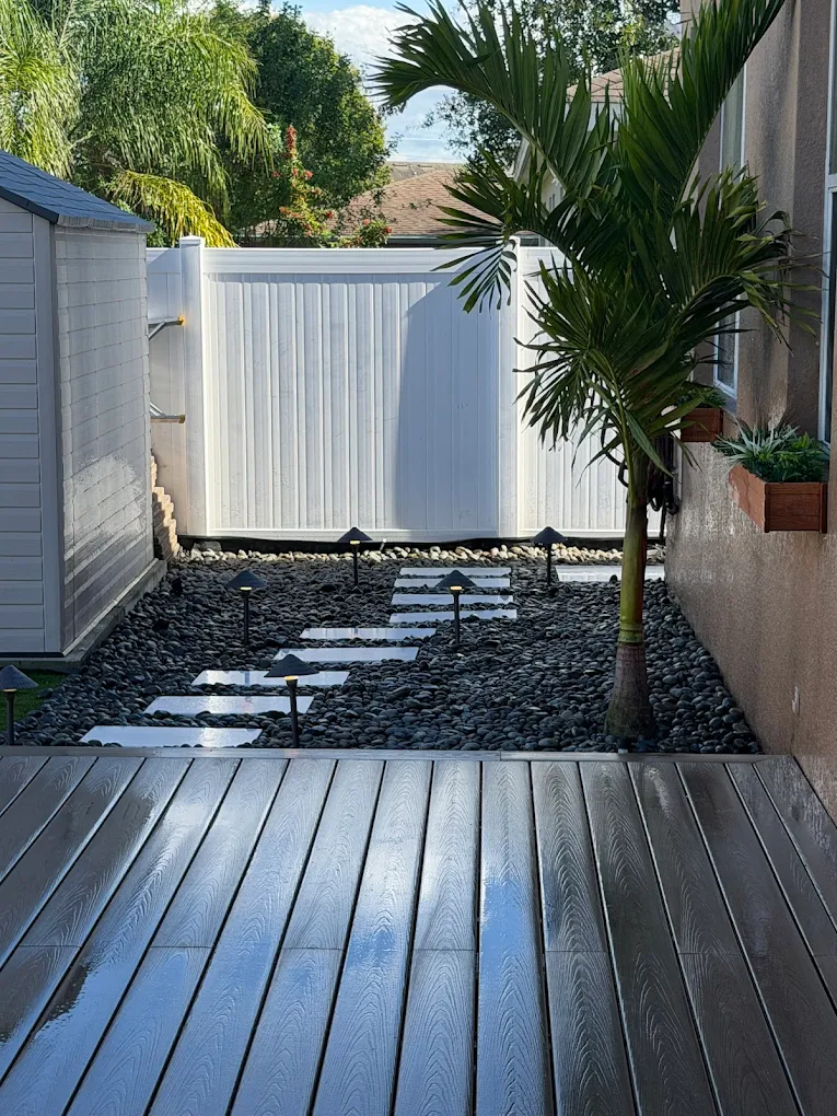 Composite deck walkway with a stepping-stone path along the side of a home